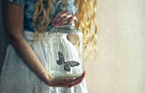 femme portant un vase de crystal avec un papillon