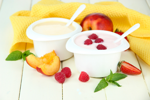 Yaourt eaux fruits et morceaux de fruits avec serviette jaune sur une table