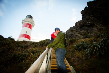 Un père qui monte les escalier d'un phare