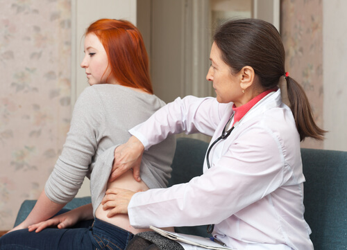 un docteur touche les reins d'une patiente