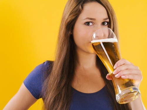 Une femme en train de boire une bière