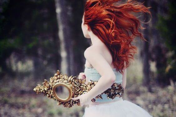 Femme rousse avec miroir dans la main