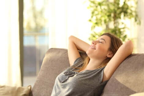 Femme affalée sur un canapé, l'air heureux 