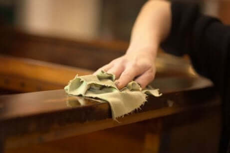 Femme en train de nettoyer un meuble en bois