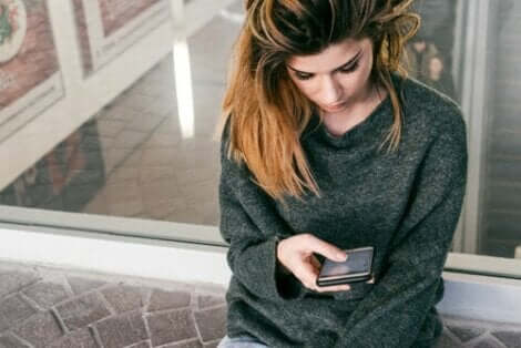 Une femme inquiète qui regarde son téléphone.