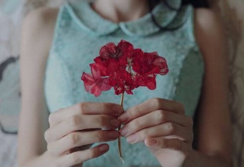 l'humilité - photo d'une jeune fille tenant une fleur rouge 
