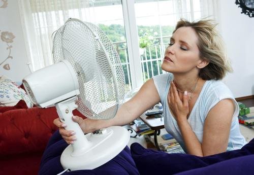 femme qui a la ménopause souffrant de bouffées de chaleur