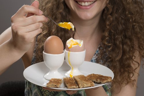 Femme qui mange des oeufs a la coque