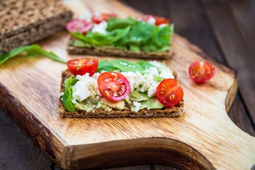 crackers aux graines agrémentés de tomates, de salade et de fromage frais