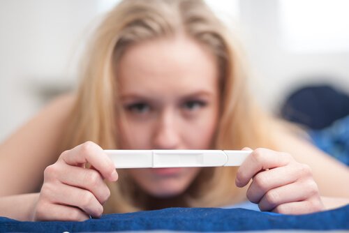 Femme qui tient un test de grossesse entre les mains
