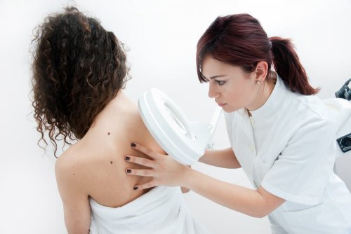Dermatologue qui analyse le grain de beauté suspect d'une patiente