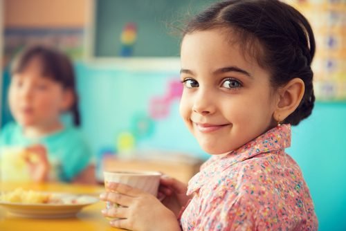 Petite fille avec une tasse à la main