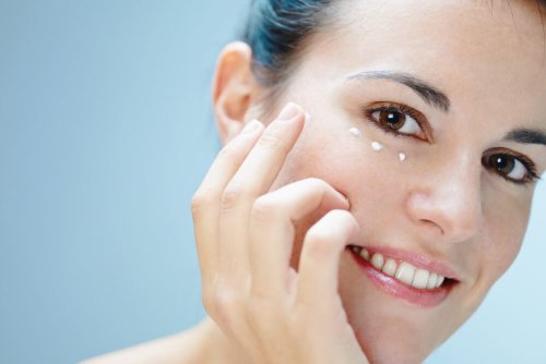 Femme qui met de la crème sous les yeux pour éviter les cernes 