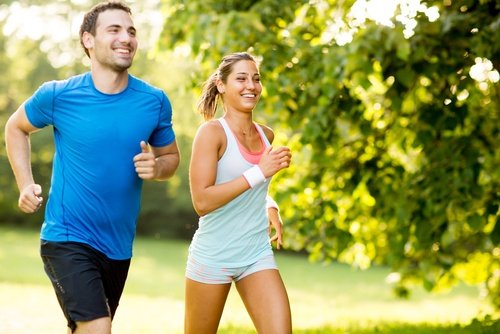 Une femme et un homme qui font un jogging l'air heureux