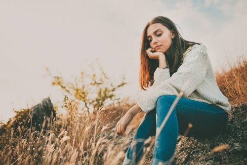 Femme assise dans un champ contrôler l'anxiété