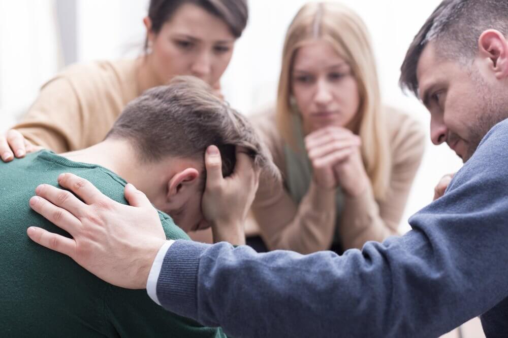 homme triste soutenu par ses amis