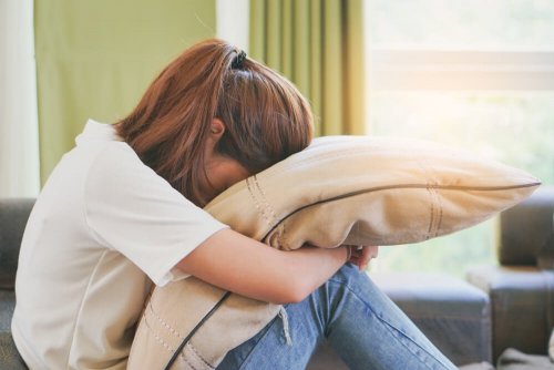 femme avec la tête enfouie dans un coussin