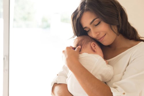 une mère qui porte son bébé dans ses bras
