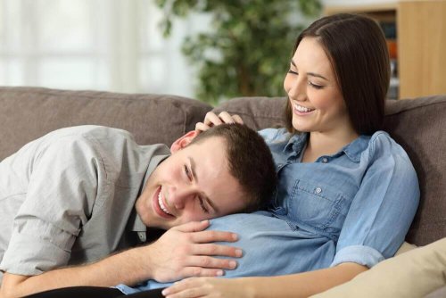 papa met la main sur le ventre de sa femme et écoute les coups de pieds