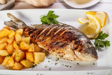 Délicieux loup de mer au four avec pommes de terre et oignons