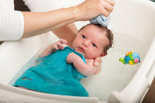 mère qui donne le bain à son bébé pour faire baisser la fièvre