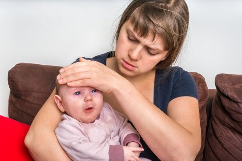 Une mère contrôle la fièvre de son bébé