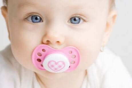 Un bébé avec sa tétine dans la bouche