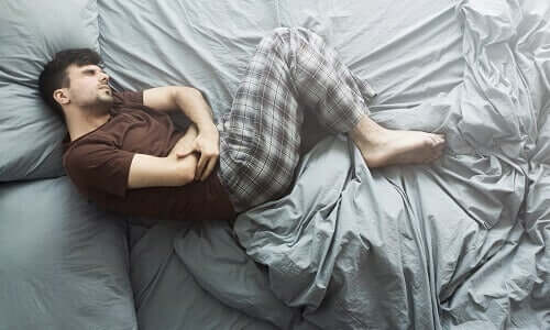 Un homme couché qui souffre de maux de ventre