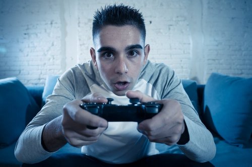 Un adolescent est absorbé par son jeu vidéo