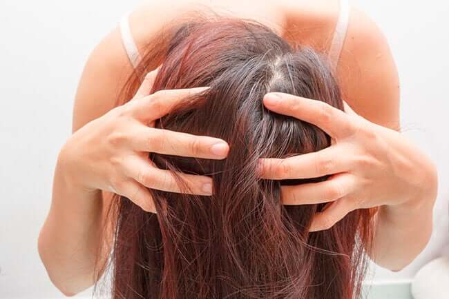 Une femme se massant les cheveux avec une de nos préparations au romarin