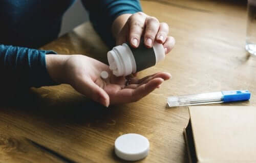 Une personne prenant des pilules pour remédier à l'aphonie