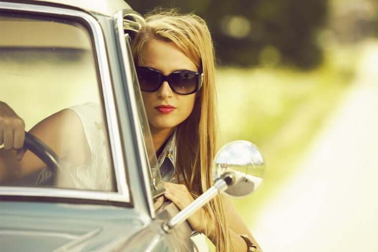 Une femme conduisant avec des lunettes de soleil