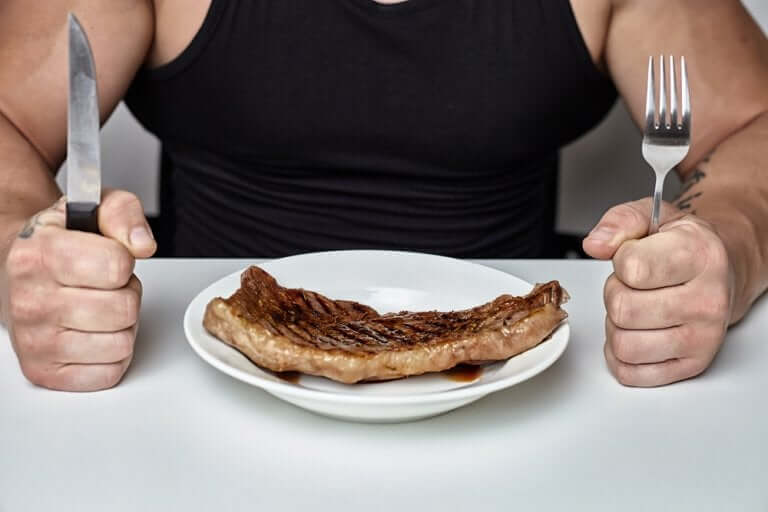Un homme musclé mangeant de la viande