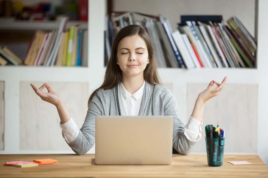 Une femme en train de méditer au travail pour lutter contre le syndrome post-vacances