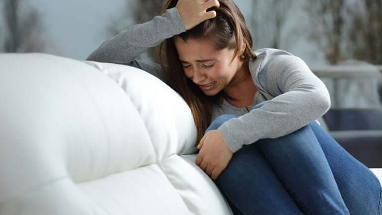 Une femme en train de pleurer à cause de pensées obsessionnelles