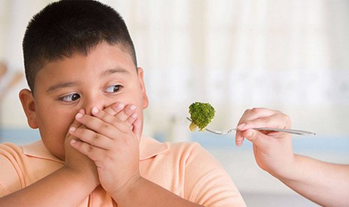 Un enfant se couvre la bouche en signe de dégoût