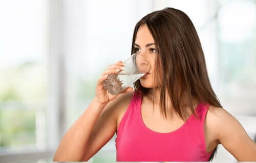 Une femme en train de s'hydrater pour éviter la constipation chronique