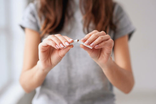 Une femme qui casse une cigarette en deux.