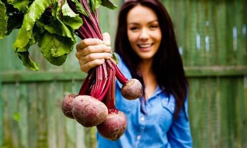 Une femme qui tient des betteraves dans sa main