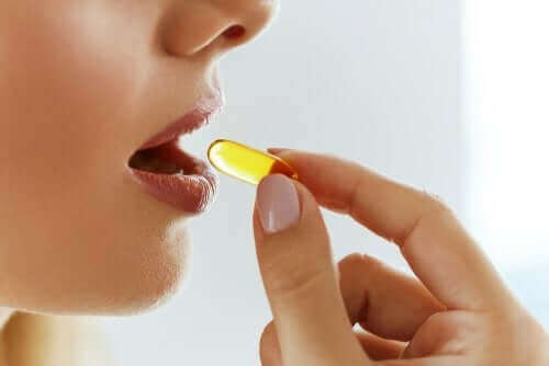 Une femme prend une gélule de vitamine K.