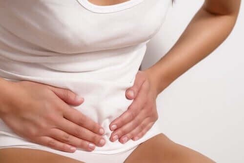 Une femme se tenant le ventre à cause de douleurs intermenstruelles