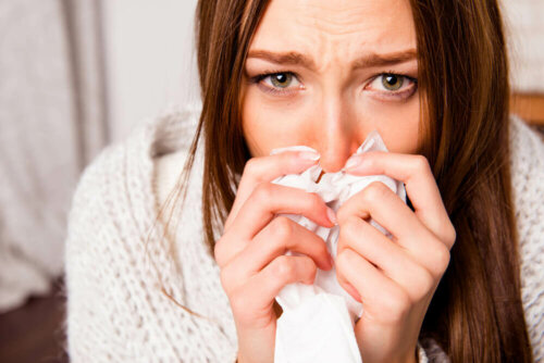 Une femme en train de se moucher à cause d'une allergie