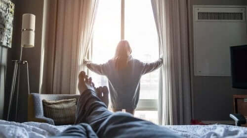 Une femme qui ouvre les rideaux