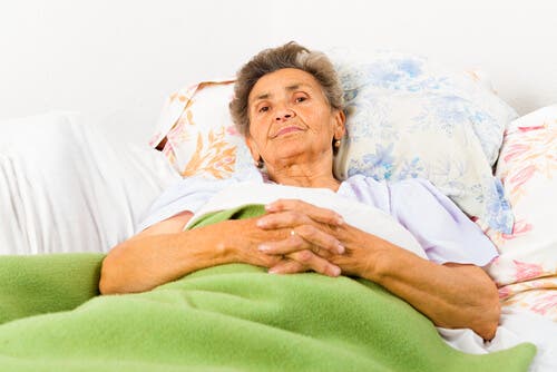 Une femme âgée couchée sur son lit ayant un mauvais rythme du sommeil