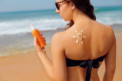 Une femme à la plage avec de la crème solaire sur le dos