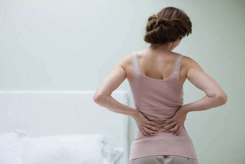 Une femme qui a des maux de dos car elle souffre de fibromyalgie