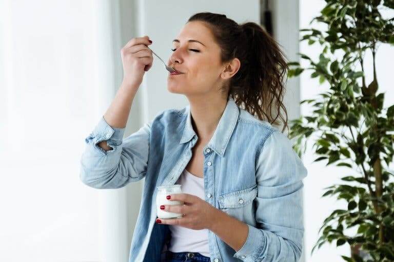 Une femme mangeant un yaourt pour apaiser la vaginose bactérienne