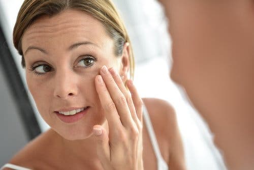 Une femme appplique de la crème au collagène sur son visage pour réduire la présence des rides