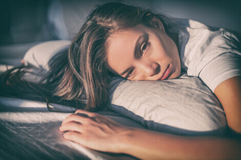 Une femme pensive et triste dans son lit souffrant de dysfonction sexuelle féminine