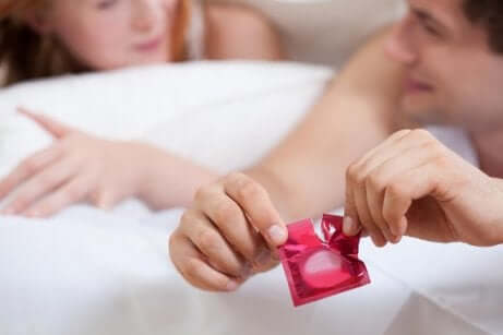 Un couple au lit avec un préservatif. 